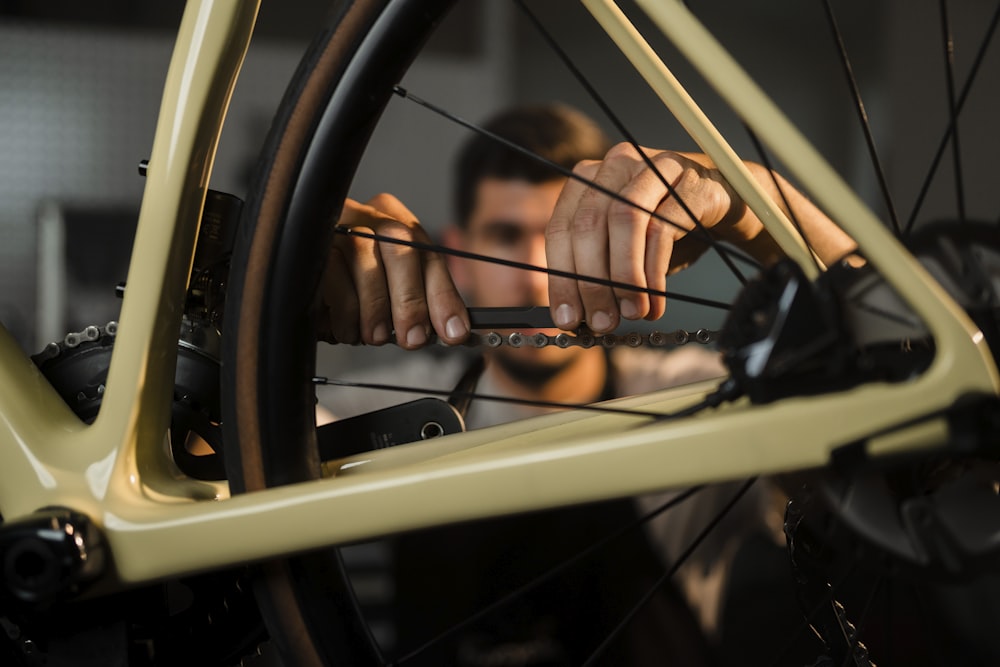 a man working on a bicycle wheel with a wrench