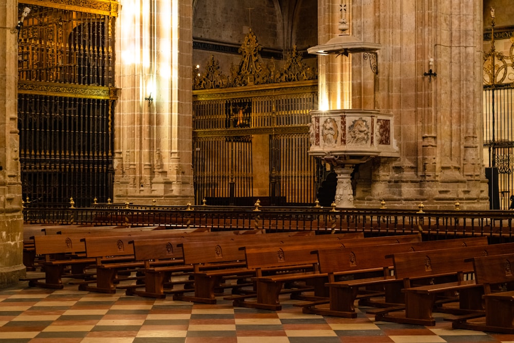 rows of benches in a church with a clock on the wall