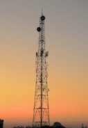 A panoramic shot of a ham radio antenna tower silhouetted against a sunset over Montana hills