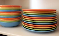 A cozy kitchen scene featuring colorful stoneware plates and bowls stacked neatly.