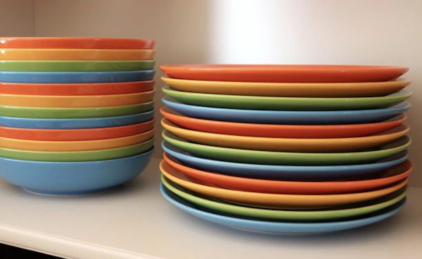 A stack of colorful plastic plates ready for bulk shipment in a bright warehouse.