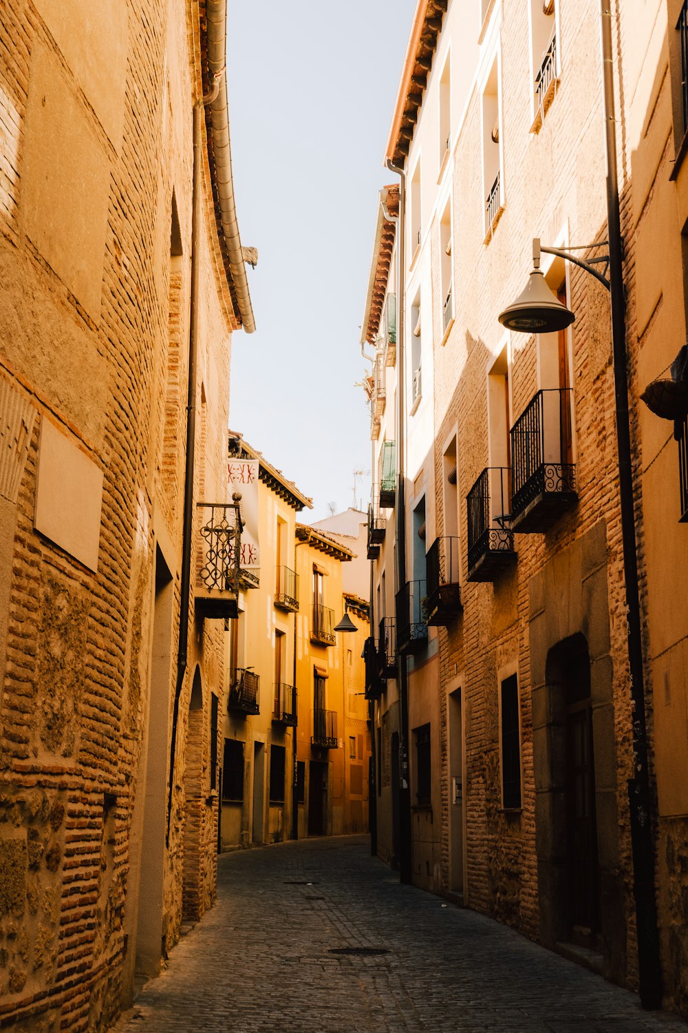 a narrow alleyway between two buildings with balconies