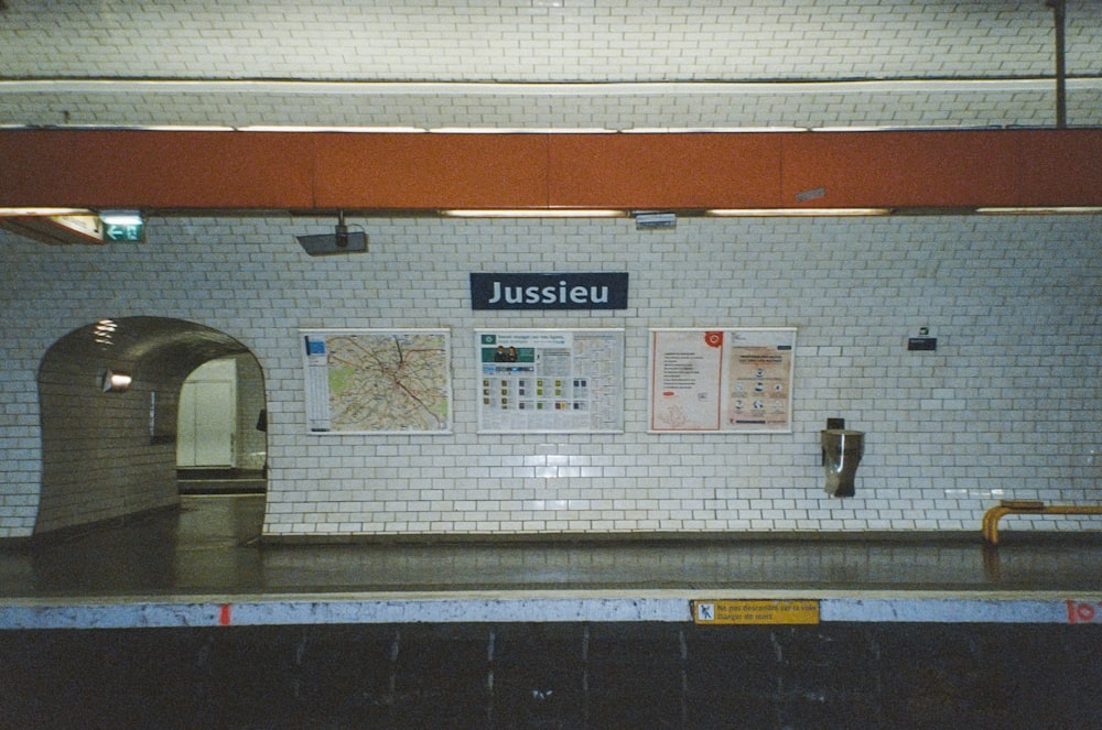 a subway station with a sign on the wall