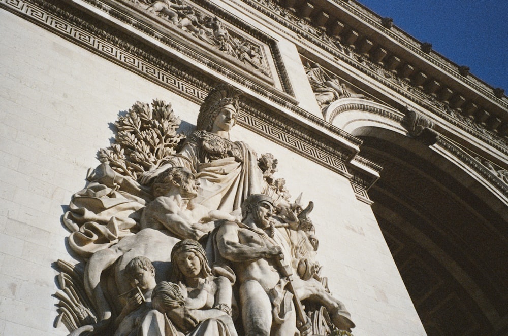 a close up of a statue on the side of a building