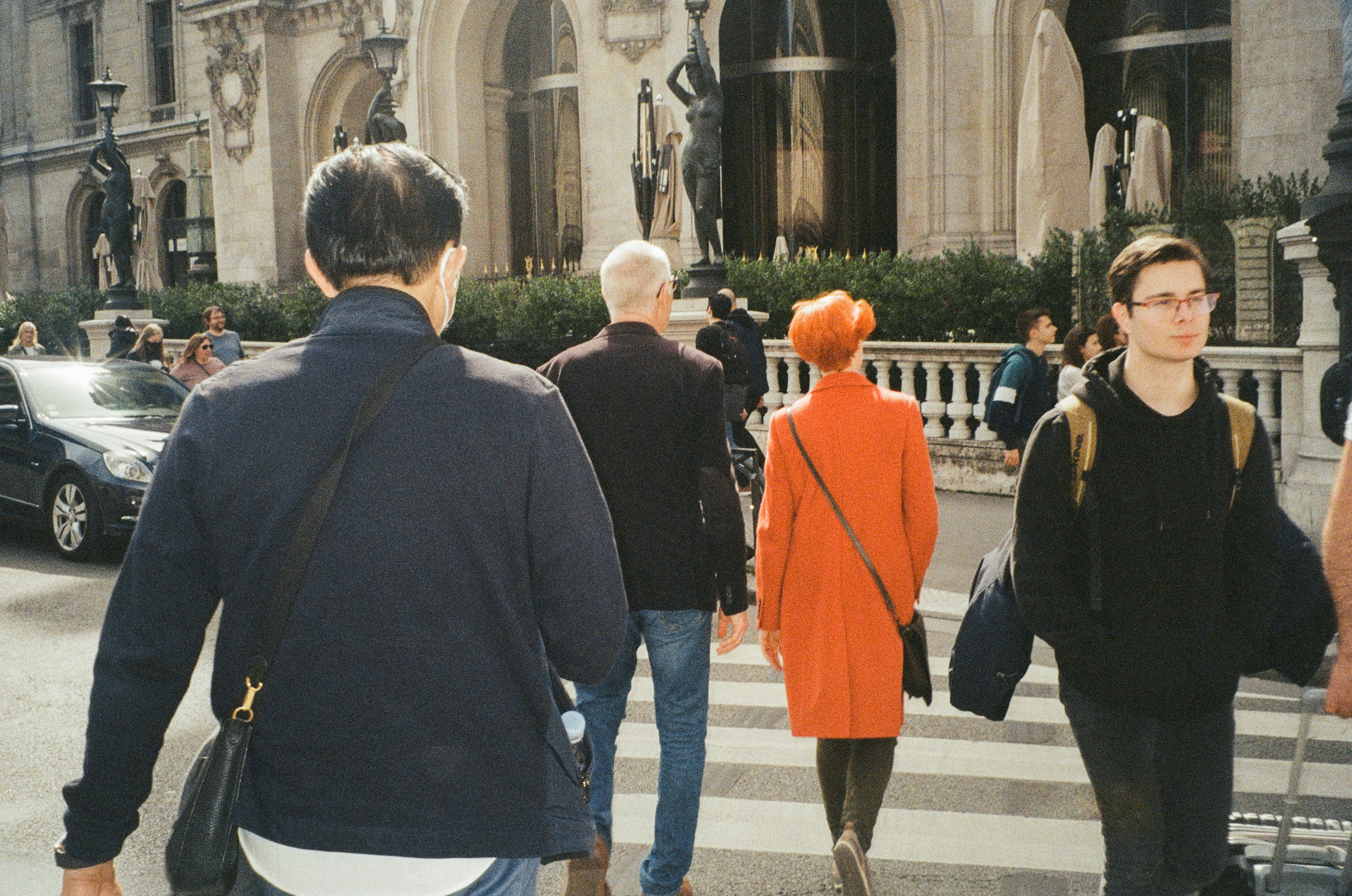 a group of people walking across a street
