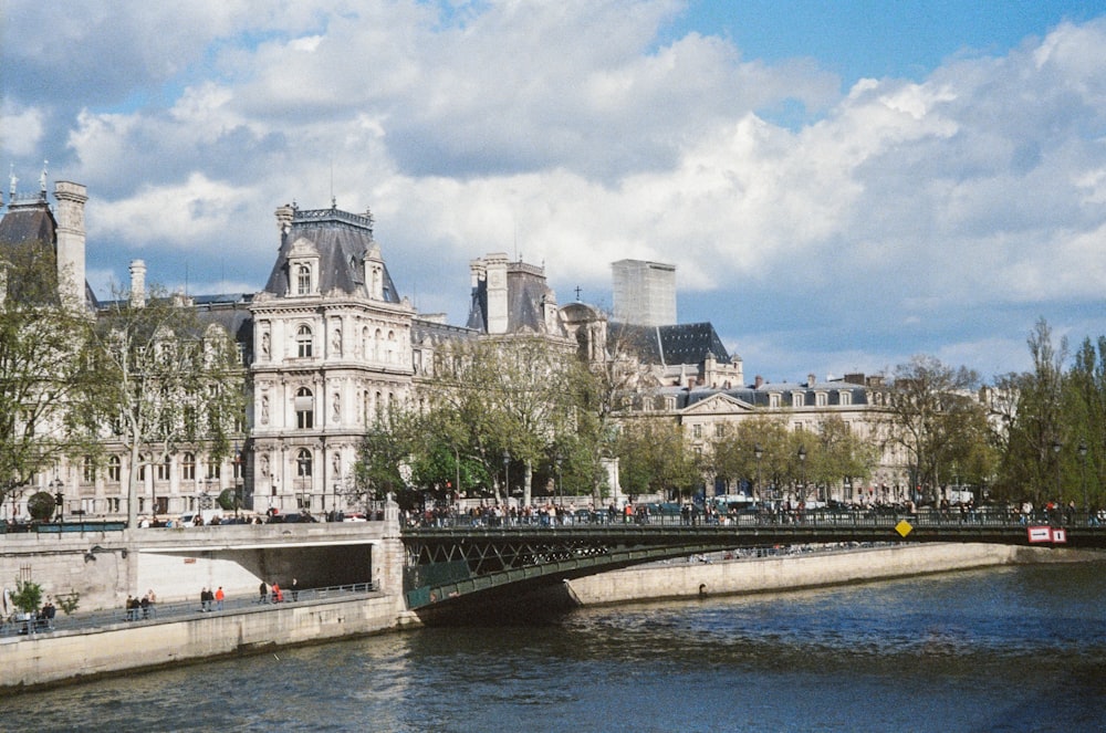 a bridge over a body of water in front of a large building