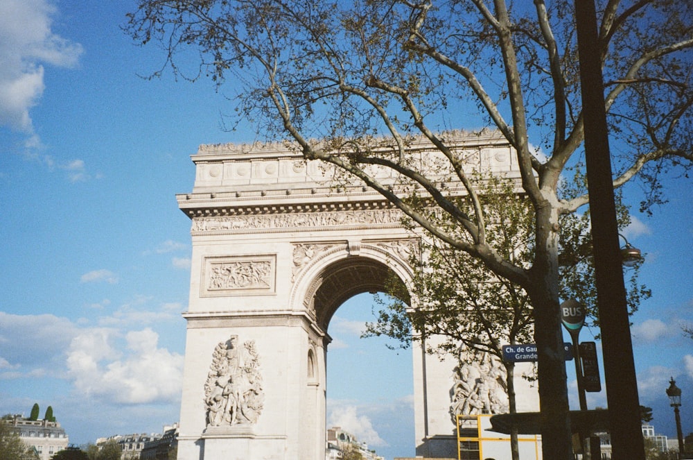 a tall white monument with a tree in front of it