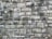 A close-up view of a rustic stone wall, showing a variety of large and small rectangular stones carefully arranged and mortared together. The stones display different shades of gray and some signs of weathering, enhancing their textured, rough surface.