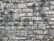 A close-up view of a rustic stone wall, showing a variety of large and small rectangular stones carefully arranged and mortared together. The stones display different shades of gray and some signs of weathering, enhancing their textured, rough surface.