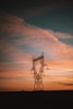a power line with the sun setting in the background