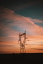 a power line with the sun setting in the background
