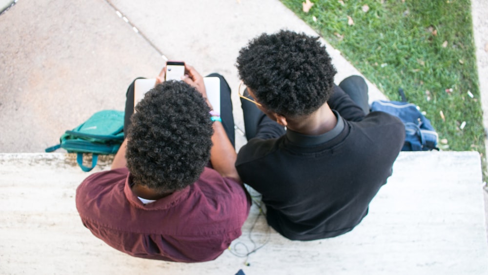 a couple of people sitting on top of a bench