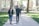 A smiling parent and child walking together outside a school building.