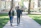 Father and son happily walking on school campus with books in hand