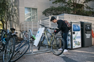 A cyclist locking their bike at a designated parking area.