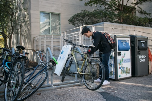 A cyclist locking their bike at a designated parking area.