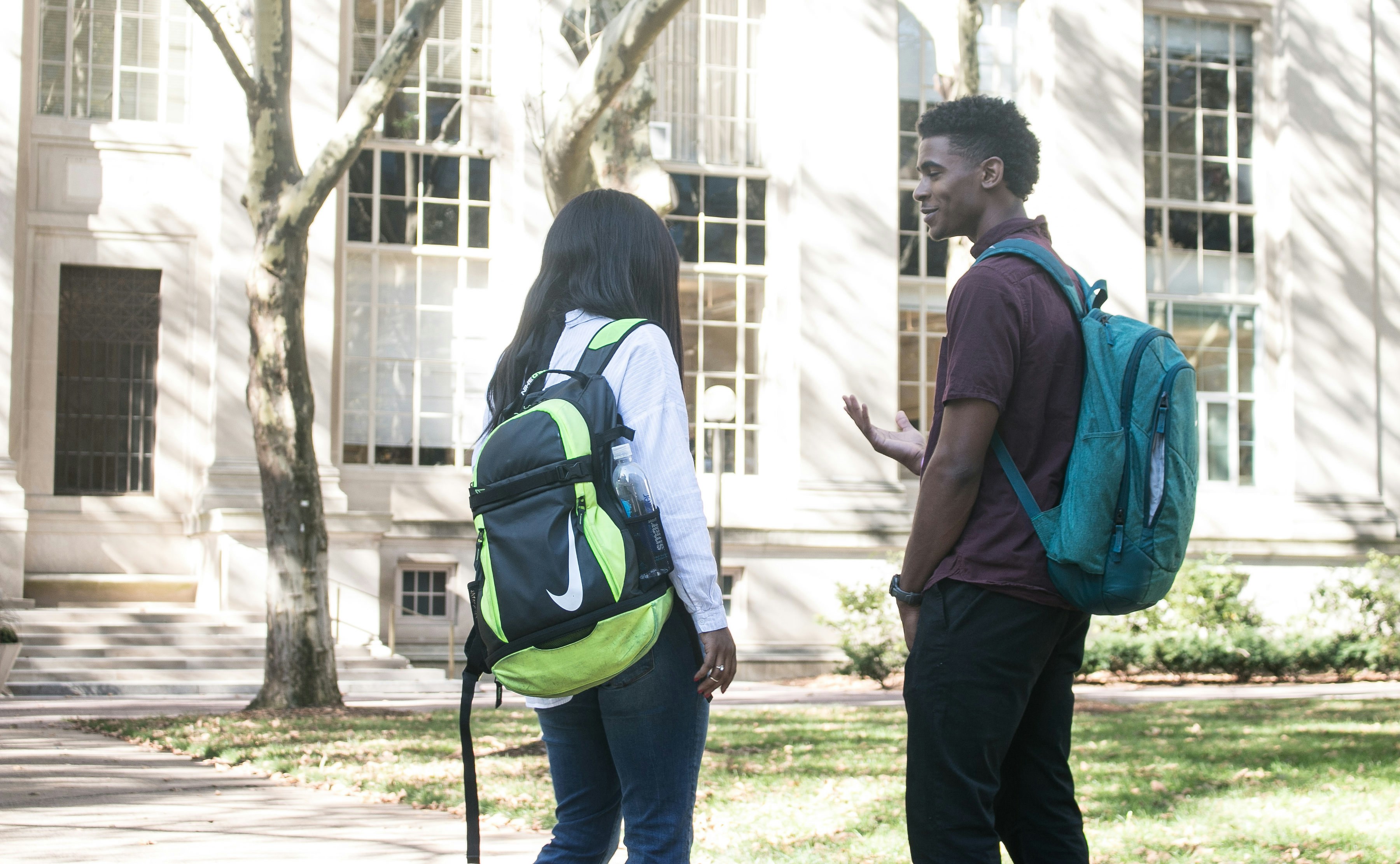 a man and a woman with backpacks talking to each other