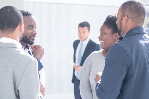 a group of people standing around talking to each other