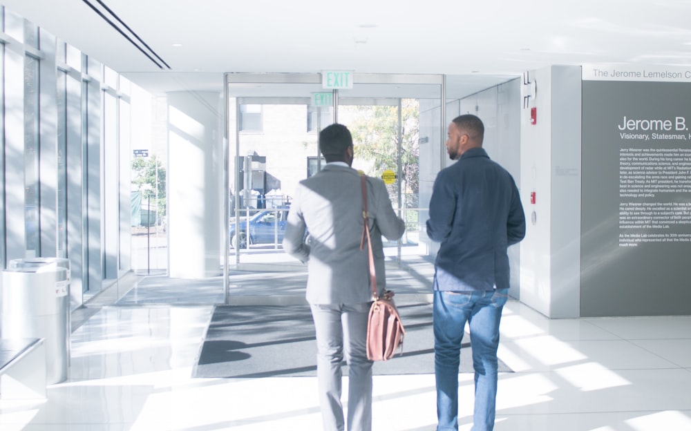 a couple of men walking down a hallway