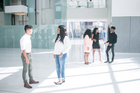 A friendly property manager discussing plans with condominium residents in a modern lobby.