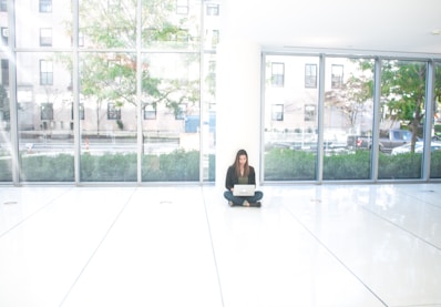 a woman sitting on the floor with a laptop