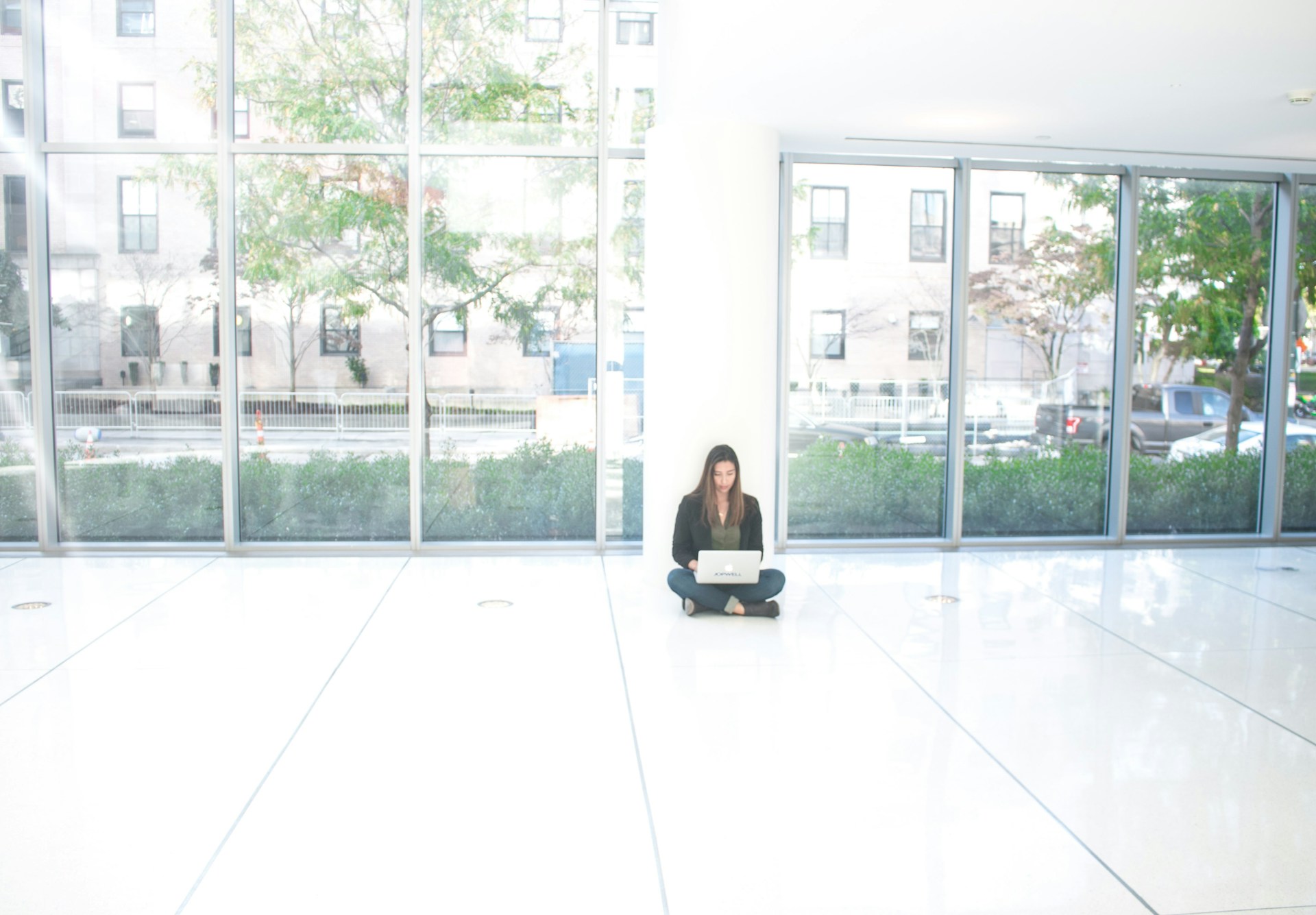 a woman sitting on the floor with a laptop