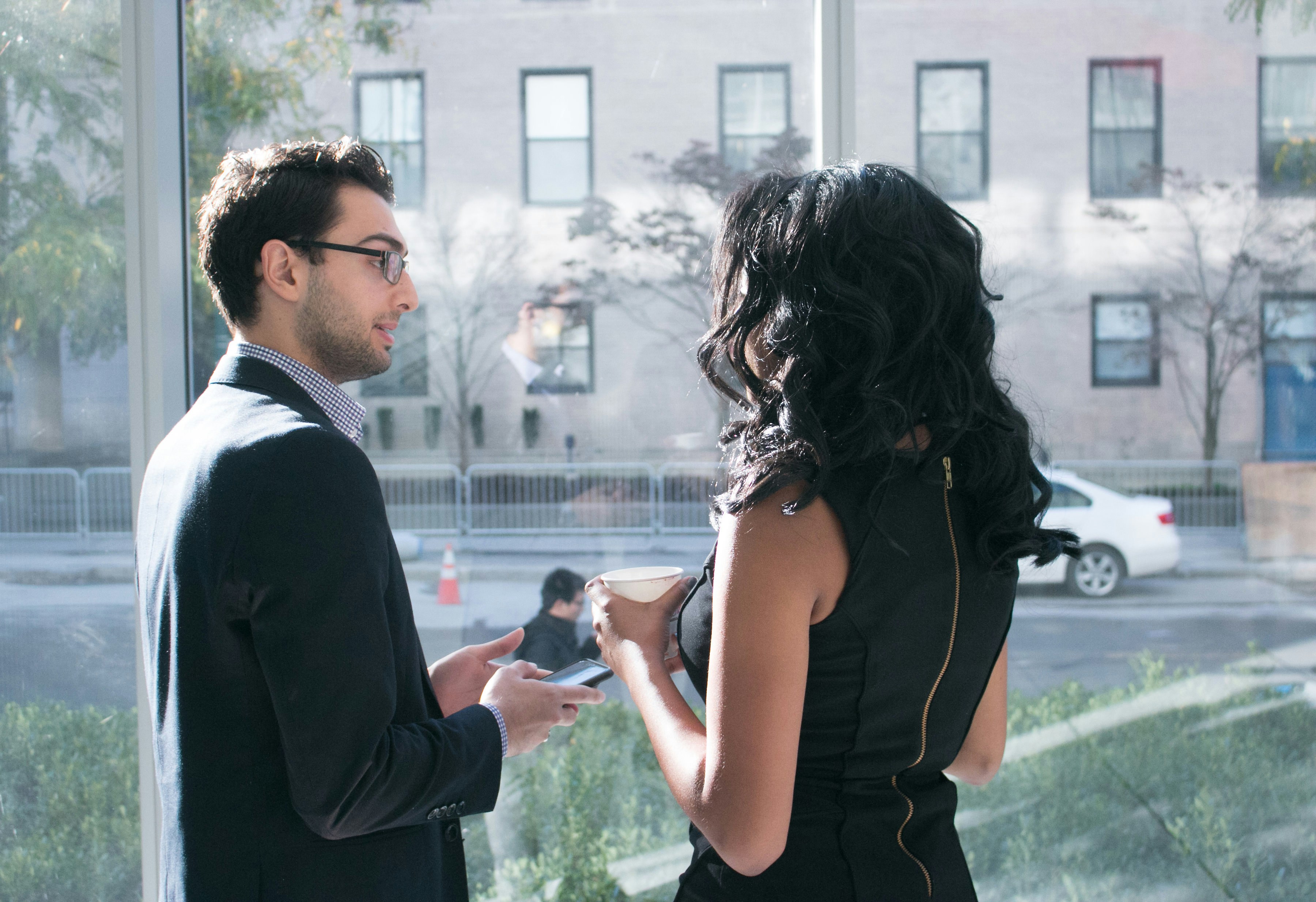 a man and a woman standing in front of a window