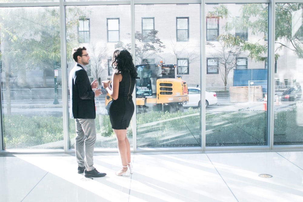 a man and a woman standing in front of a window