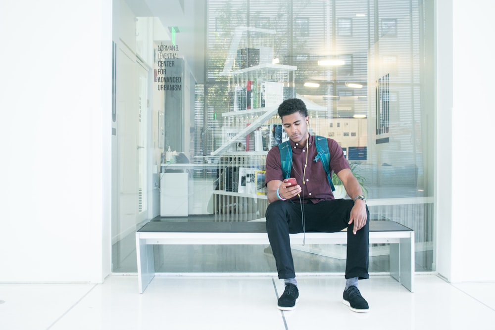 a man sitting on a bench listening to music