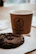 Close-up of a box of freshly baked millet cookies with a cup of steaming tea beside it.