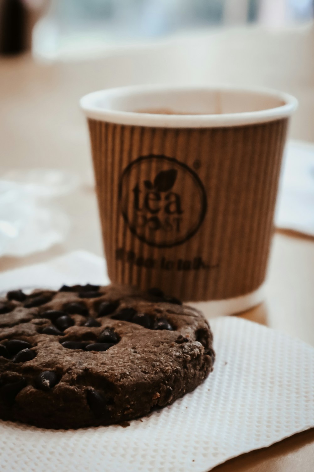 a chocolate cookie and a cup of coffee on a table