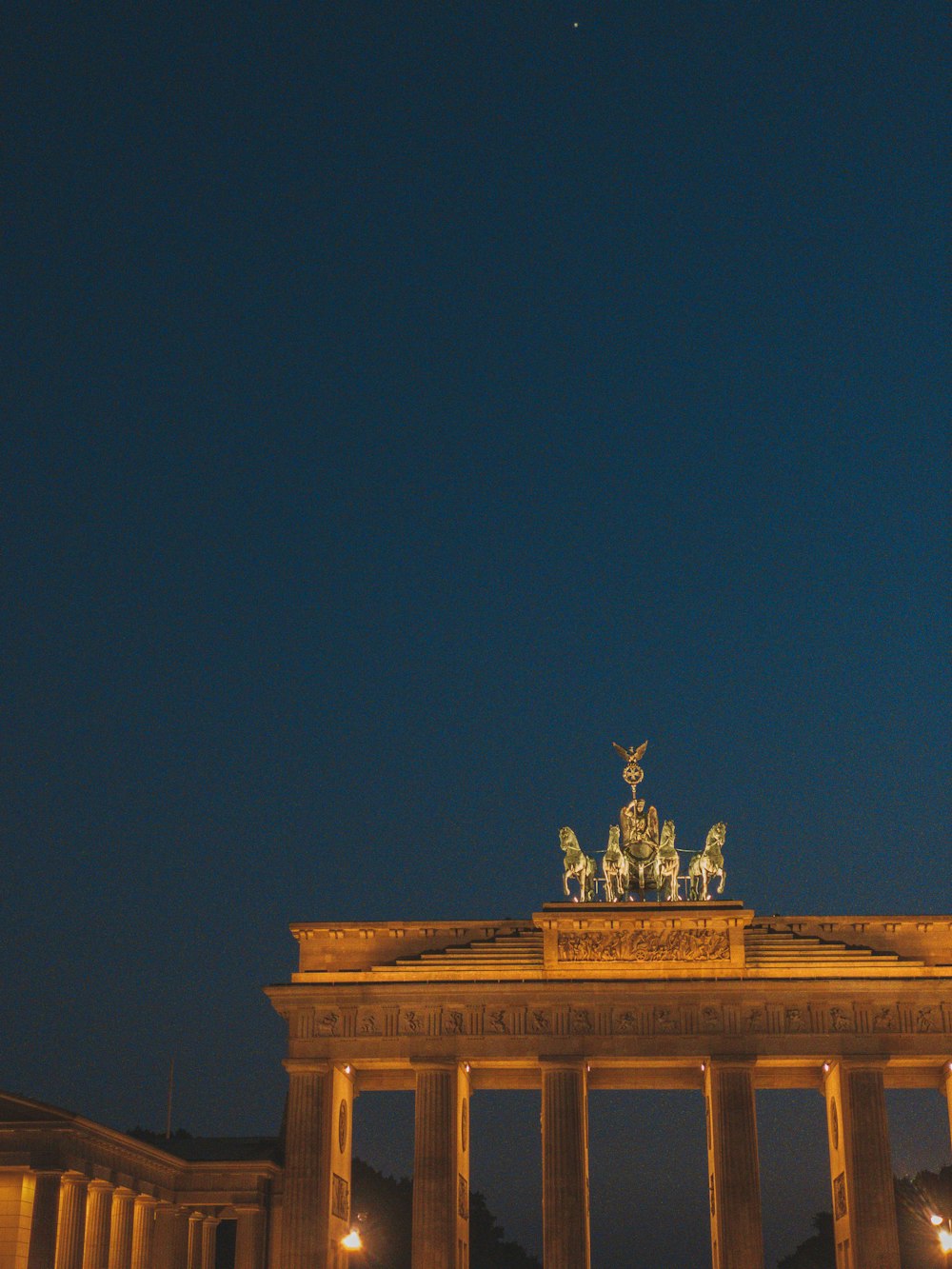 Una vista nocturna de un edificio con una estatua en la parte superior