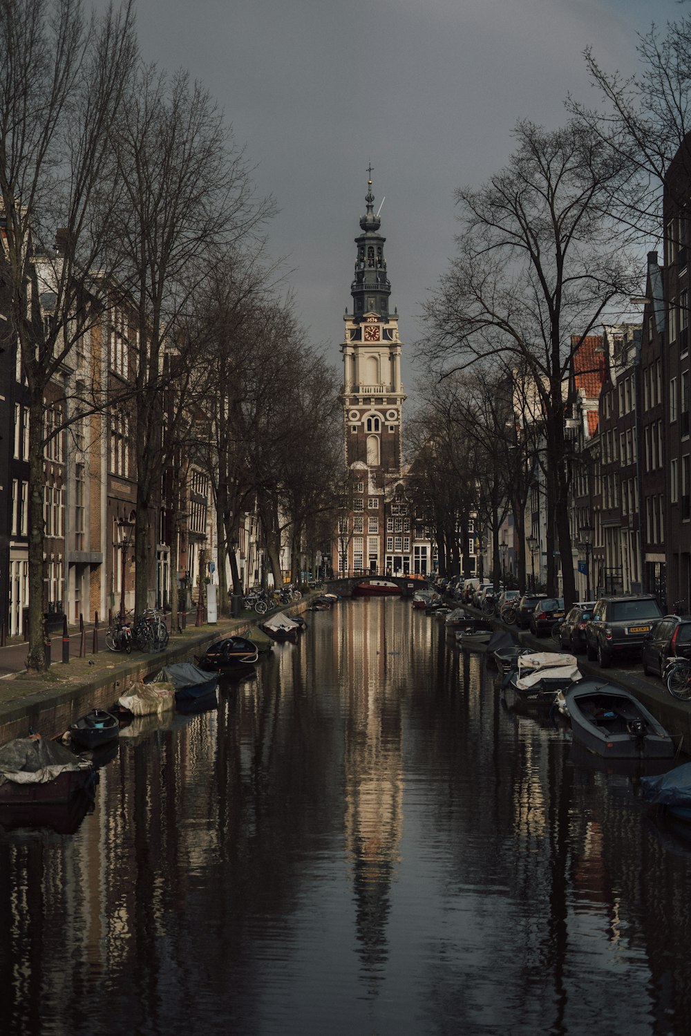 a waterway with boats and a clock tower in the background