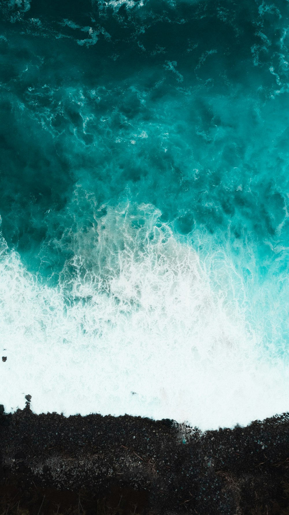 a man standing on top of a cliff next to the ocean