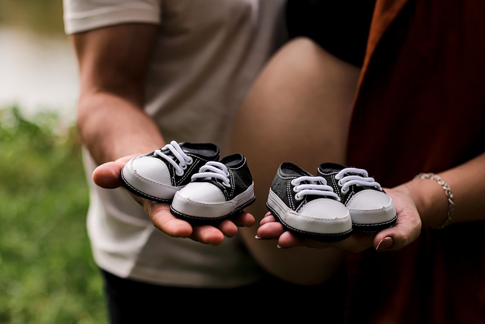 Una persona sosteniendo dos zapatos de bebé en sus manos