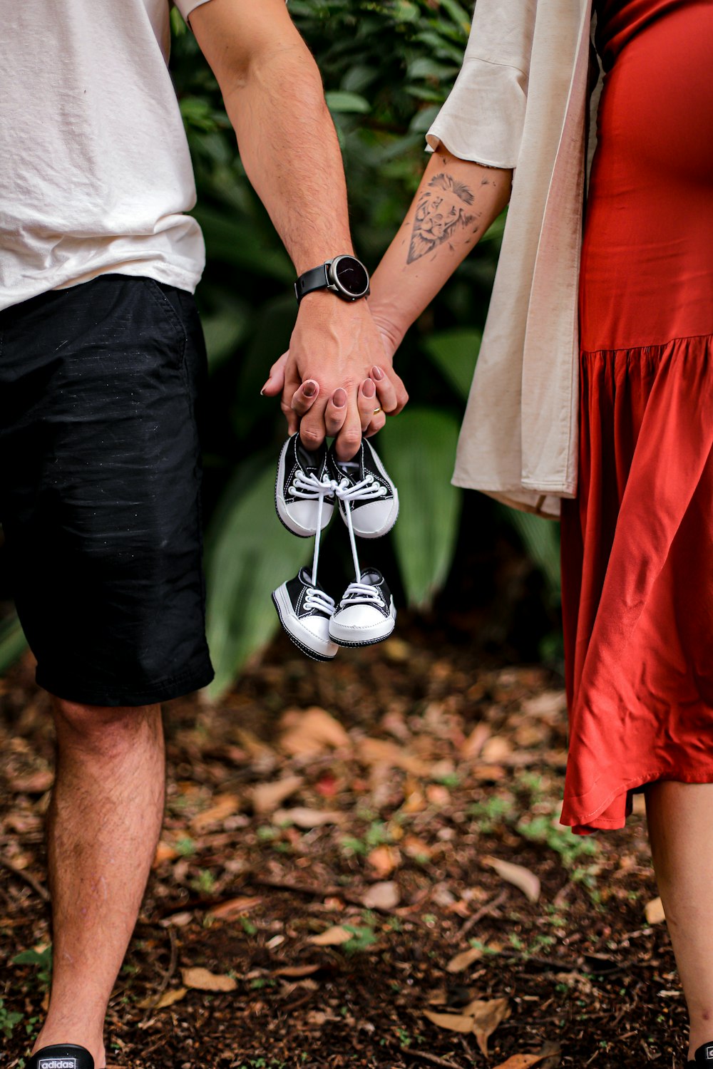 a man and a woman holding hands and holding shoes