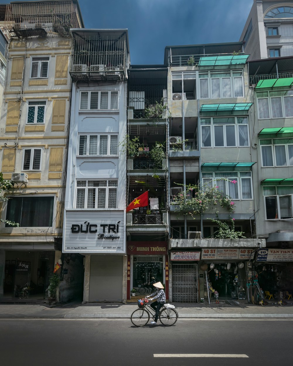 a man riding a bike past a tall building