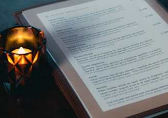 a lit candle sitting on top of a book