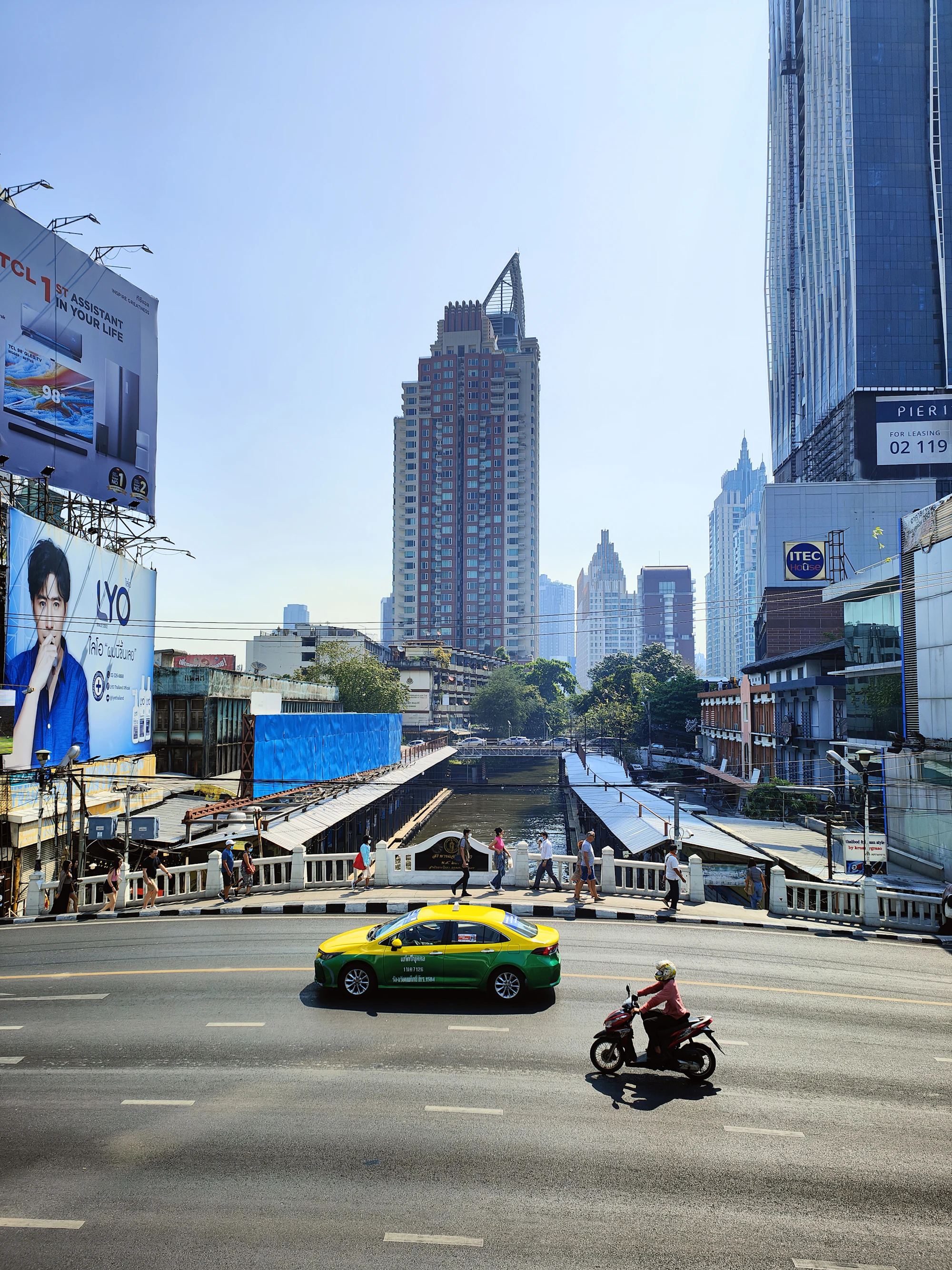 Traffic on a Bangkok street, with a taxi and motorcyclist