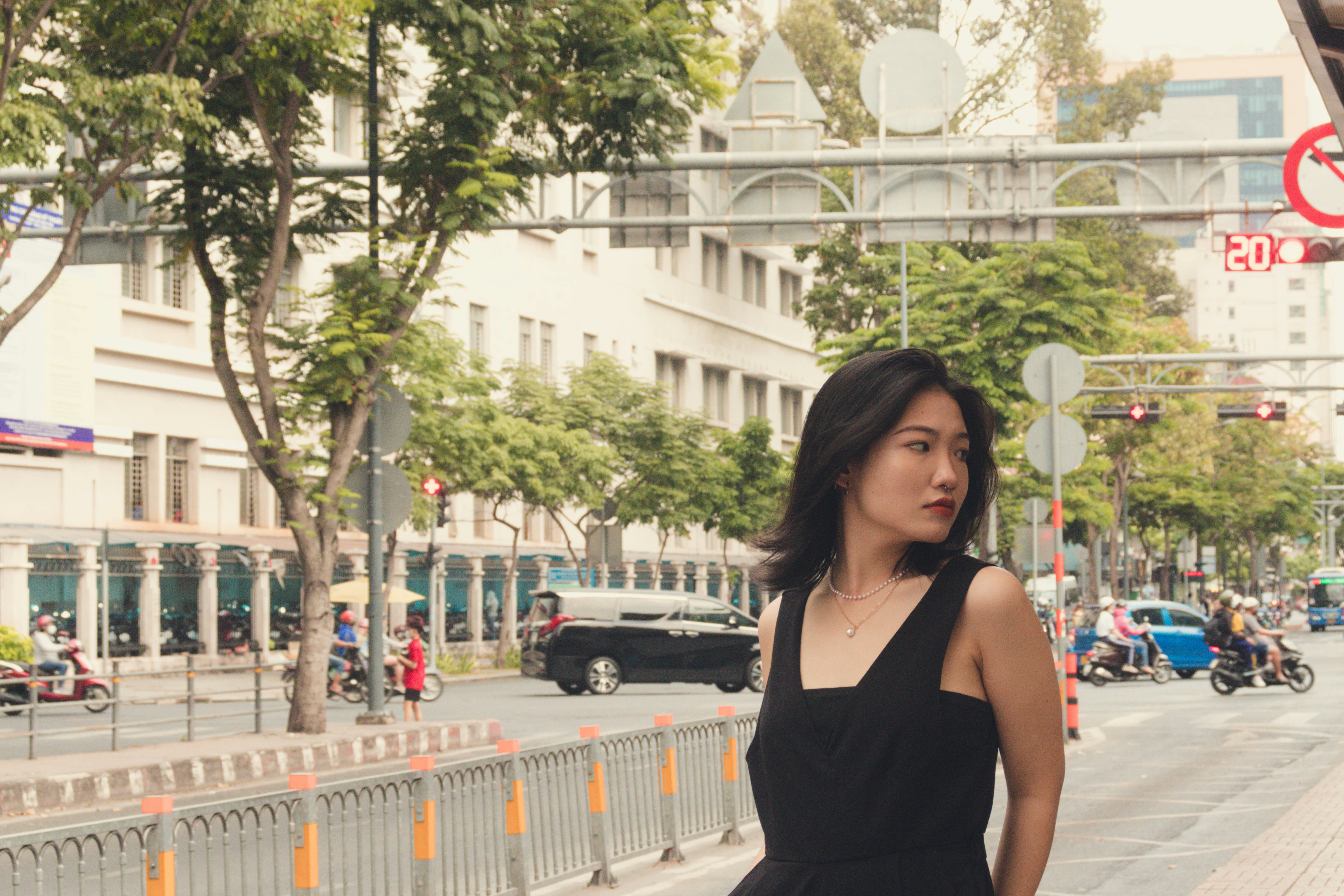 A woman in a black dress walking down a street photo – Free Woman Image ...