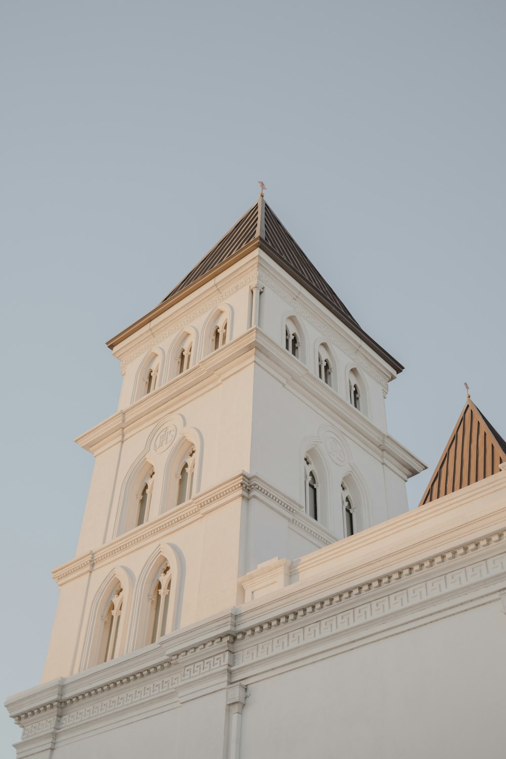 a tall white building with a clock on it's side