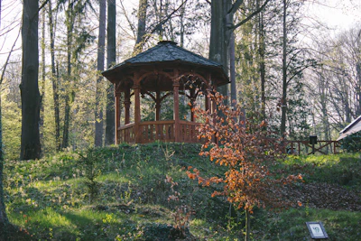 A neatly assembled wooden gazebo in a sunny backyard.