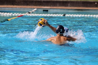 a man in a swimming pool with a ball in his hand