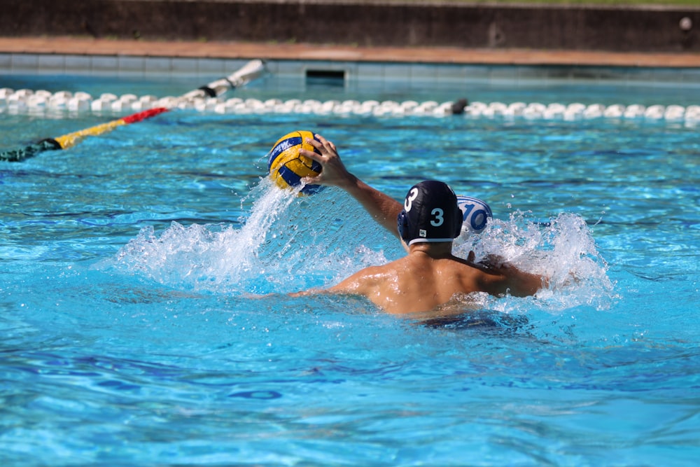 a man in a swimming pool with a ball in his hand