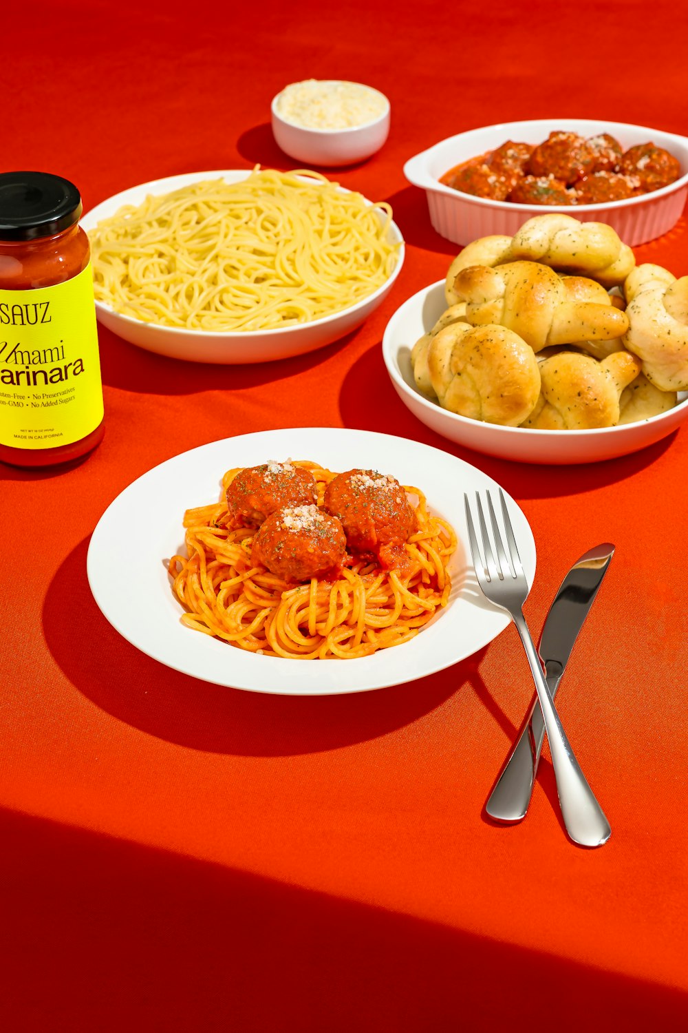 a table topped with plates of spaghetti and meatballs
