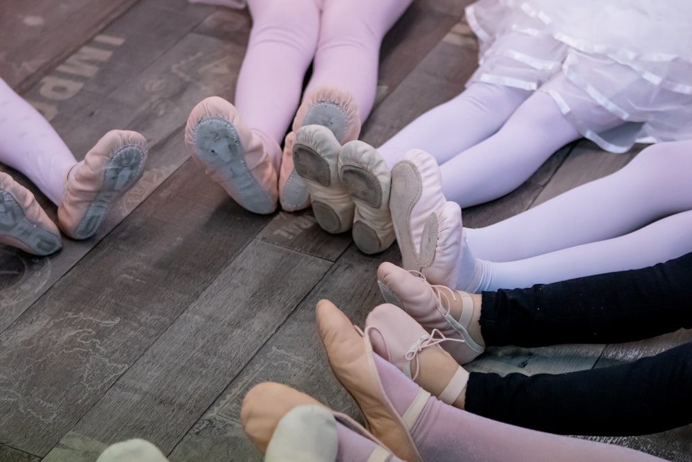 a group of ballerinas sitting on a wooden floor