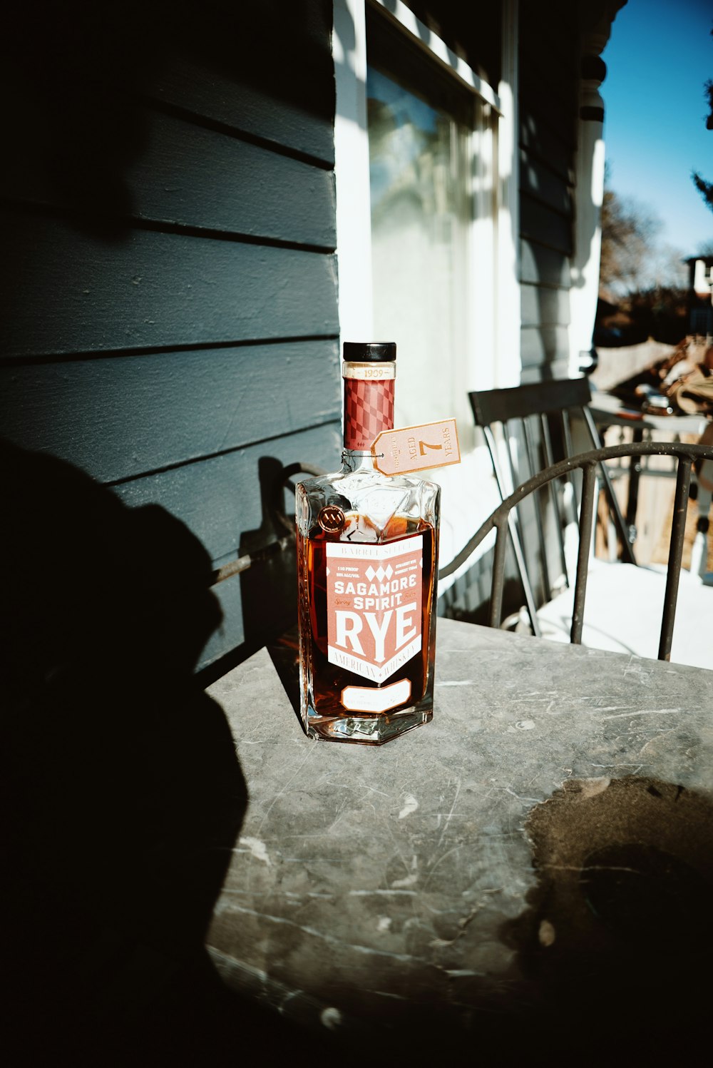 a bottle of rye sitting on a porch
