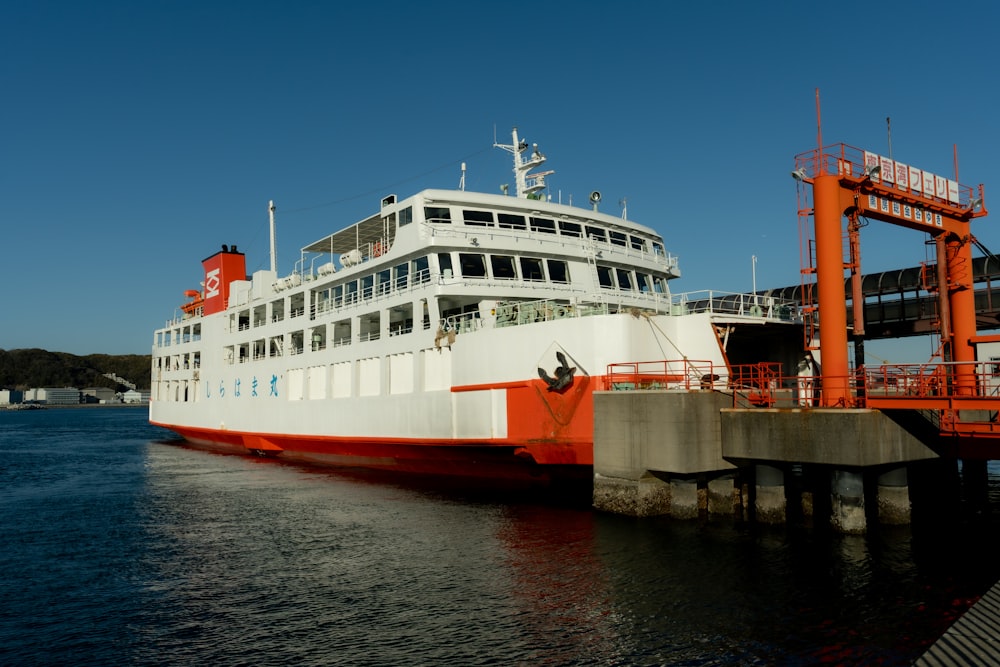 a large white and red boat docked at a dock