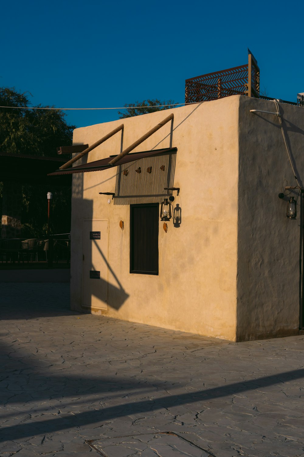 a tan building with a black door and window