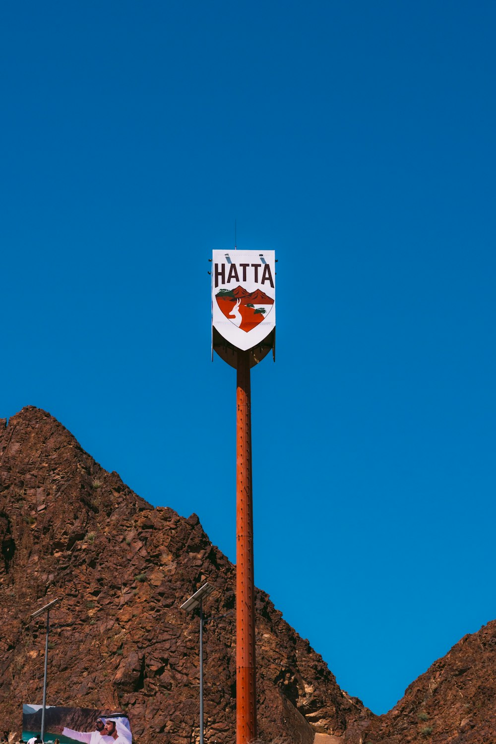 a tall red and white sign sitting on the side of a mountain